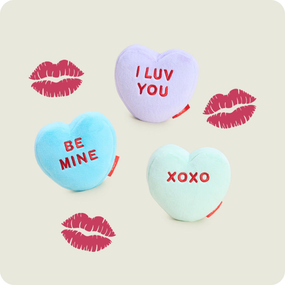 Sweetheart Warmies with 'I LUV YOU', 'BE MINE', and 'XOXO' text on a card with lipstick prints.